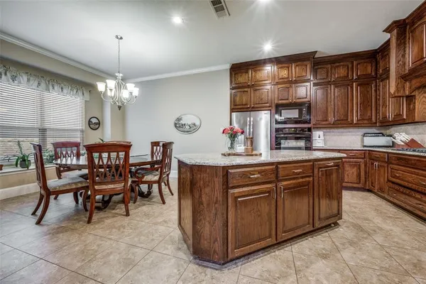 a kitchen with kitchen island granite countertop a sink counter top space appliances and cabinets