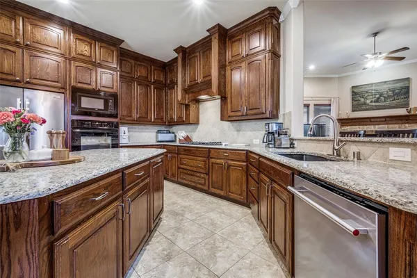 a kitchen with stainless steel appliances granite countertop a sink stove and cabinets