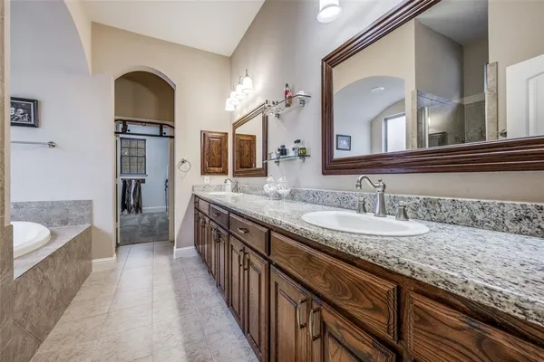a spacious bathroom with a granite countertop double vanity sink and a mirror