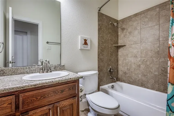 a bathroom with a granite countertop toilet a sink and a bathtub