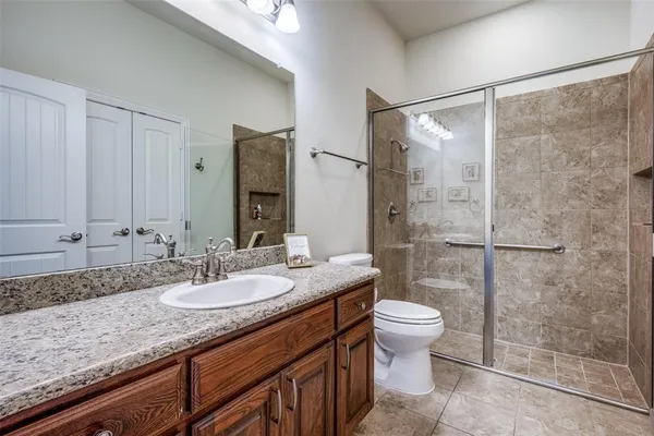 a bathroom with a granite countertop sink toilet and shower
