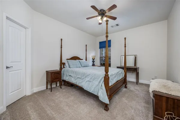 a bedroom with a bed a chandelier and a dresser
