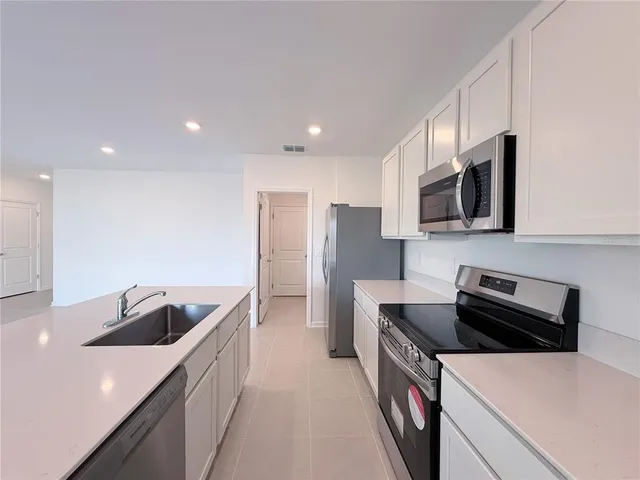 a kitchen that has a sink and a stove top oven in it