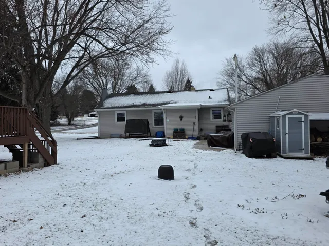 a view of a house with a yard covered with snow in the background