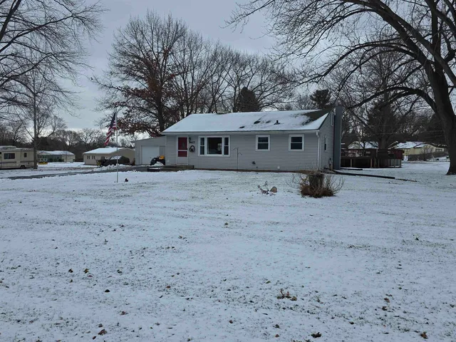 a white house that has a tree in front of it
