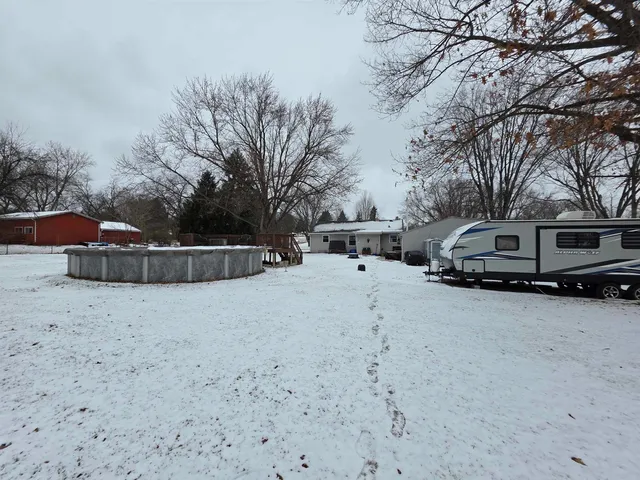 a view of a house with a yard covered in snow