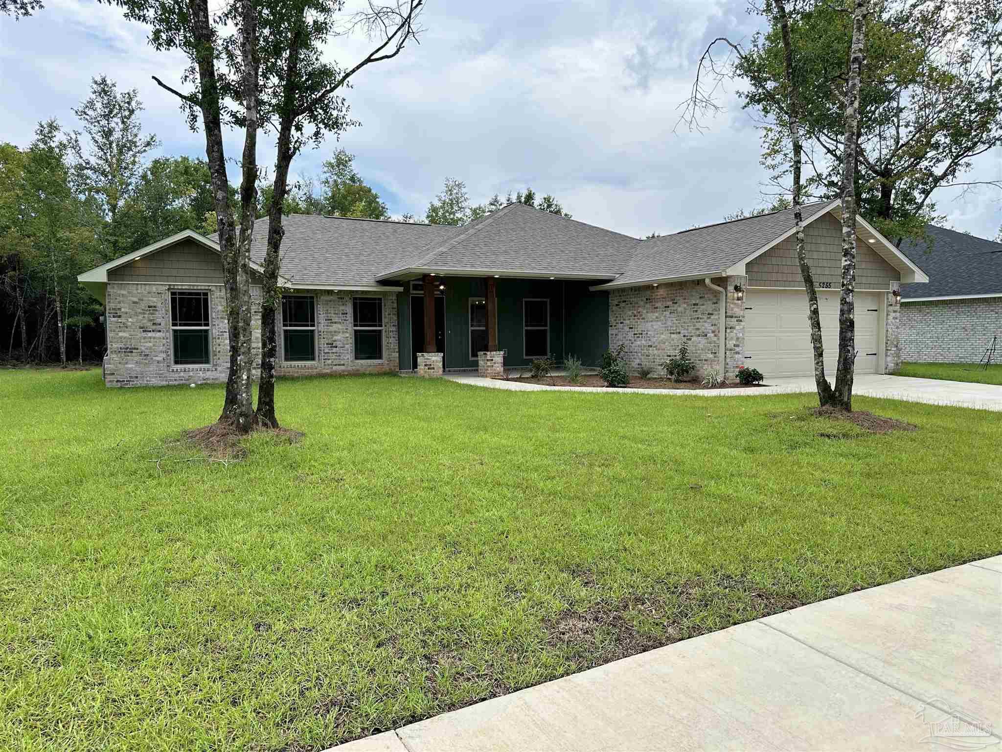 5231 Wahoo Road Milton, FL 32583 - Photo 2 of 14 a front view of a house with a yard and trees