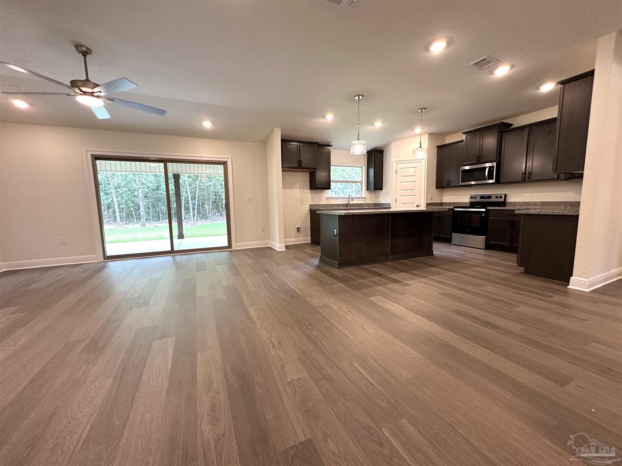 5231 Wahoo Road Milton, FL 32583 - Photo 7 of 14 a view of kitchen with kitchen island wooden floors and stainless steel appliances