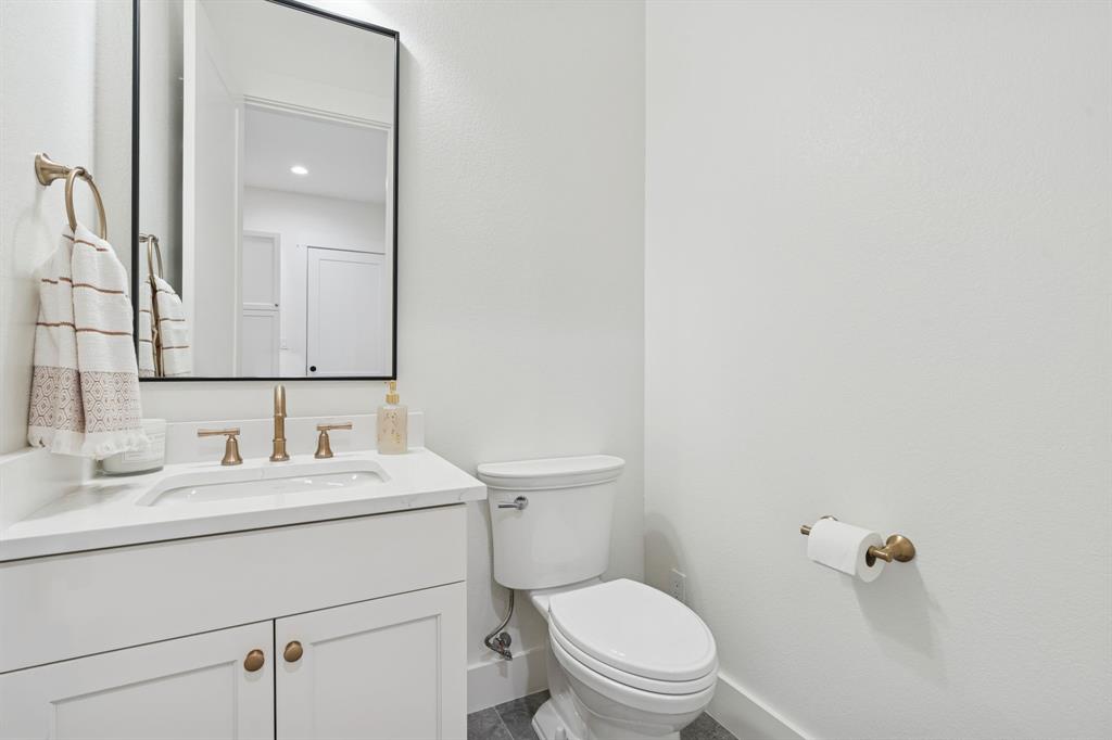 8008 Ben Day Murrin Road Fort Worth, TX 76126 - Photo 33 of 40 a bathroom with a toilet sink vanity and mirror