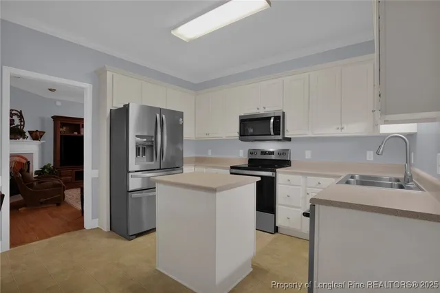 a kitchen with appliances a sink and cabinets