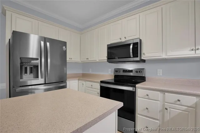 a kitchen with granite countertop white cabinets and stainless steel appliances