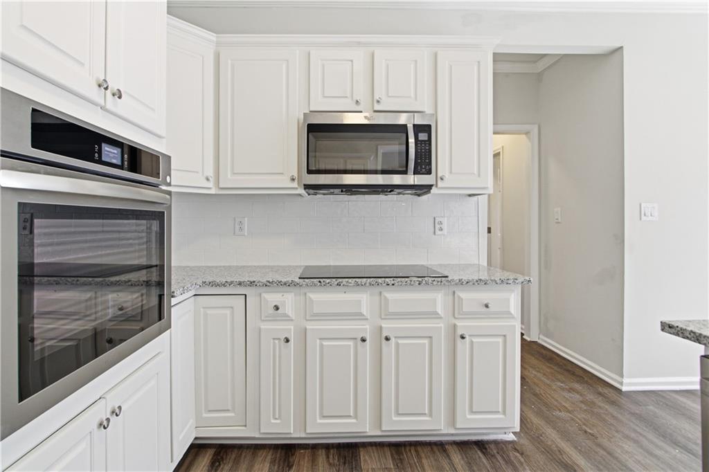 2296 Talbot Ridge Jonesboro, GA 30236 - Photo 19 of 44 a kitchen with stainless steel appliances granite countertop white cabinets and a stove a oven with wooden floor