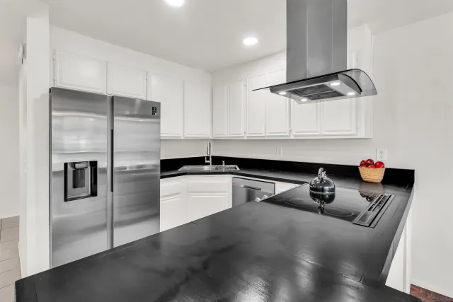 a kitchen with stainless steel appliances granite countertop a sink a stove and a refrigerator