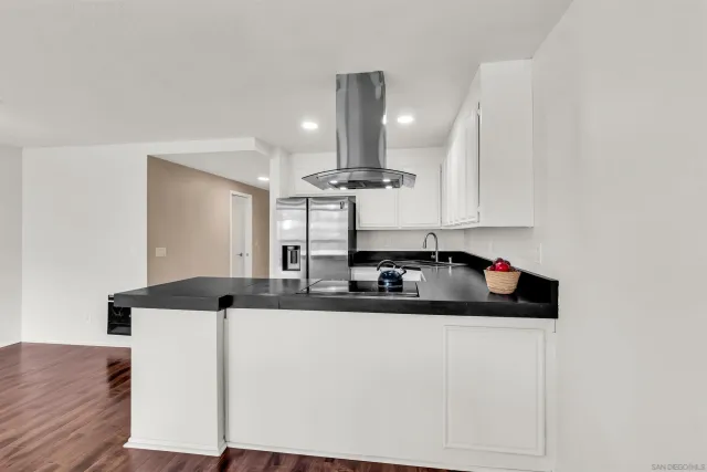a kitchen with stainless steel appliances granite countertop a sink and a refrigerator
