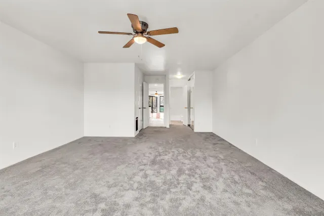 an empty room with a ceiling fan and a window