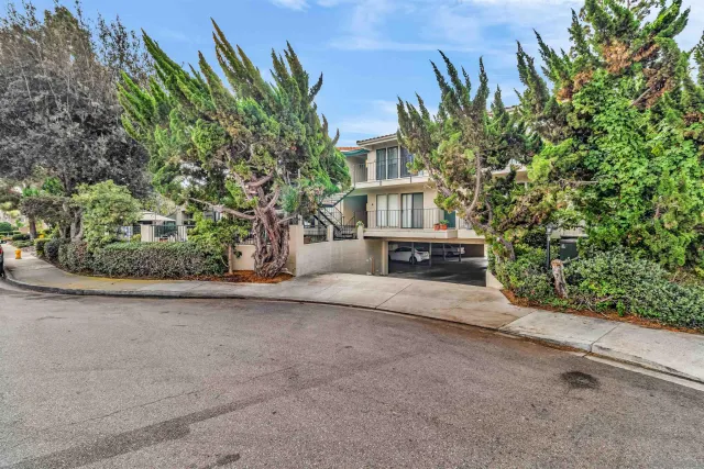 a front view of a house with a yard and potted plants