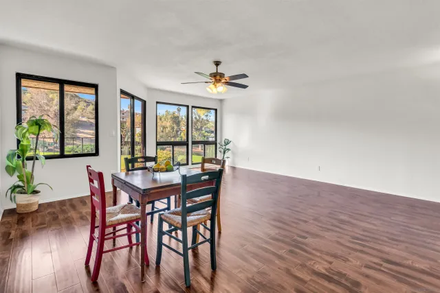 a dining room with furniture a chandelier and wooden floor