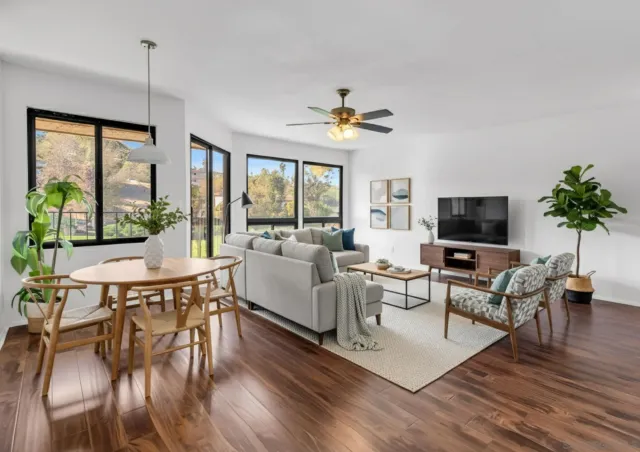 a living room with furniture a flat screen tv and a large window
