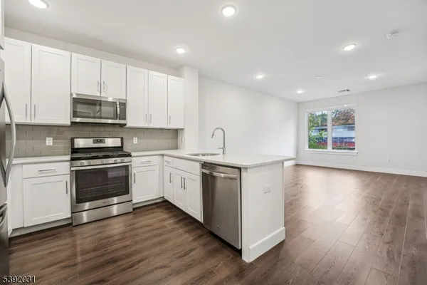 a kitchen with granite countertop white cabinets and white appliances