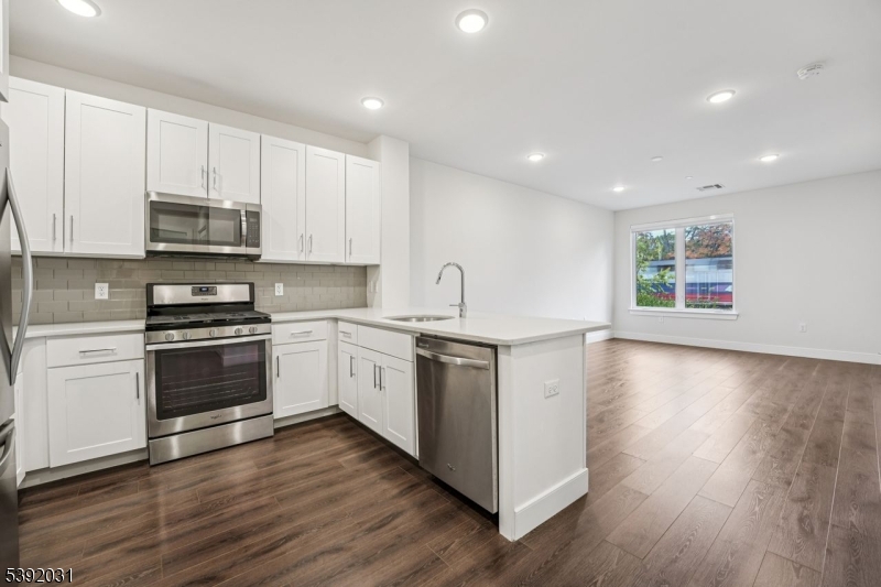 41 West Prospect Street Waldwick, NJ 07463 - Photo 3 of 19 a kitchen with granite countertop white cabinets and white appliances