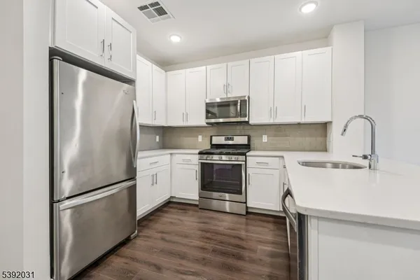 a kitchen with cabinets stainless steel appliances and a sink