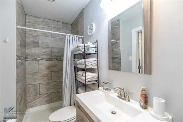 a bathroom with a sink toilet and shower