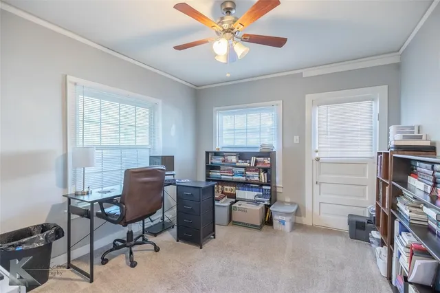 a view of a workspace with furniture and a window