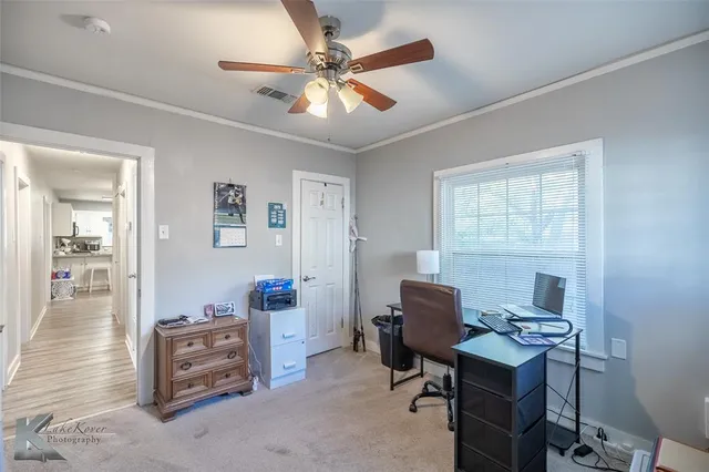 a view of a workspace with furniture and a window