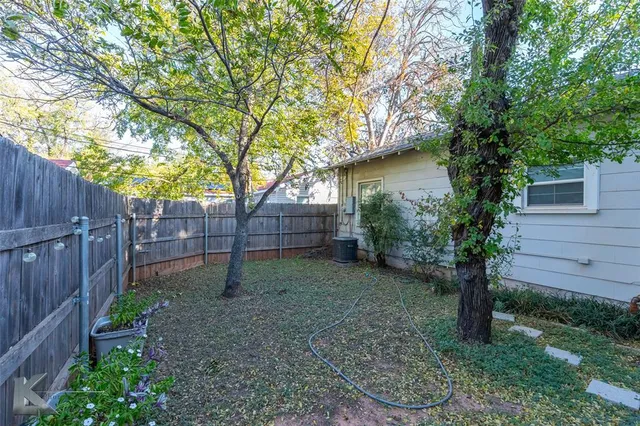 a backyard of a house with plants and wooden fence