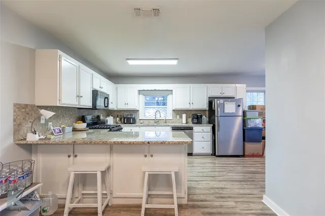 a kitchen with stainless steel appliances granite countertop a refrigerator and microwave
