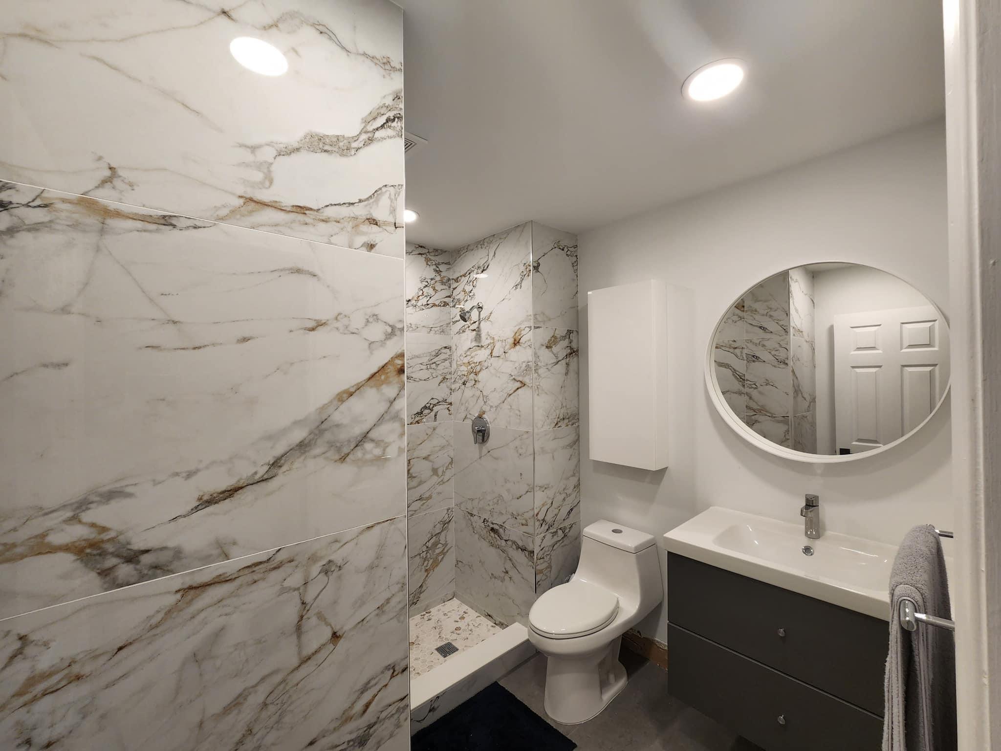 a bathroom with a sink toilet mirror vanity and shower
