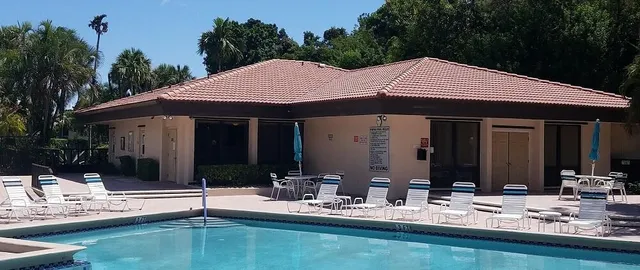 a patio with a table and chairs and potted plants