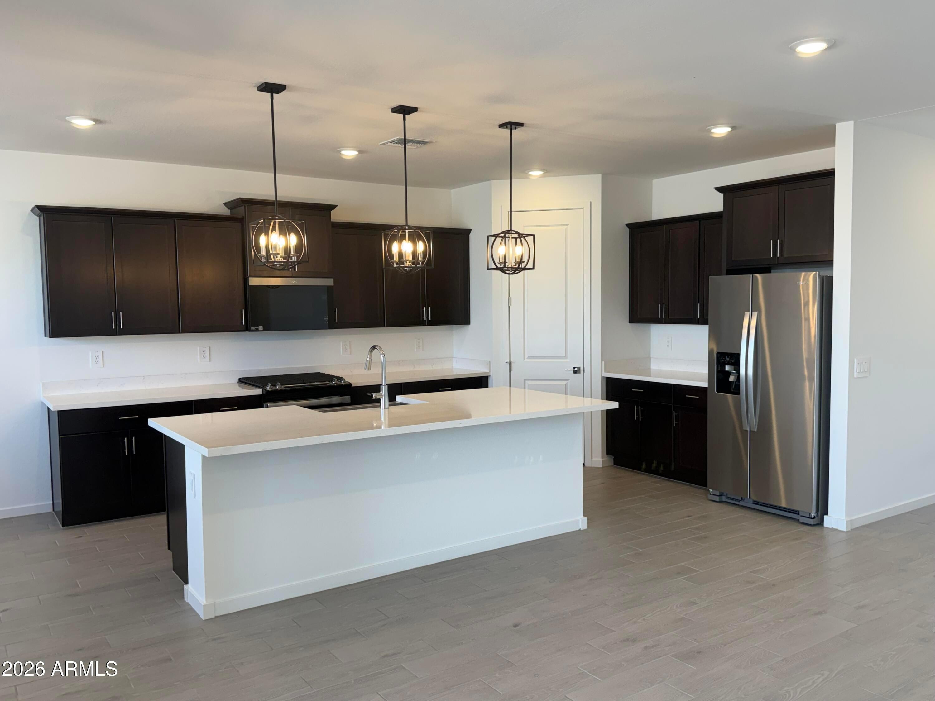2478 Grenache Road San Tan Valley, AZ 85143 - Photo 5 of 34 a large kitchen with a large counter top stainless steel appliances and cabinets