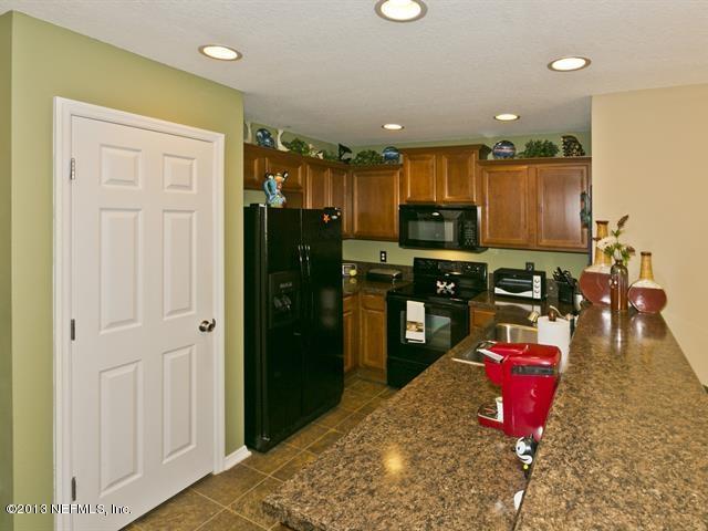 216 Michelangelo Place St. Augustine, FL 32084 - Photo 4 of 18 a kitchen with stainless steel appliances granite countertop a refrigerator stove and oven