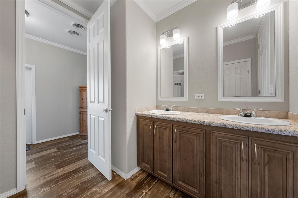 3449 Bluhm Road West, TX 76691 - Photo 22 of 40 Bathroom with ornamental molding, double vanity, and dark wood-style floors
