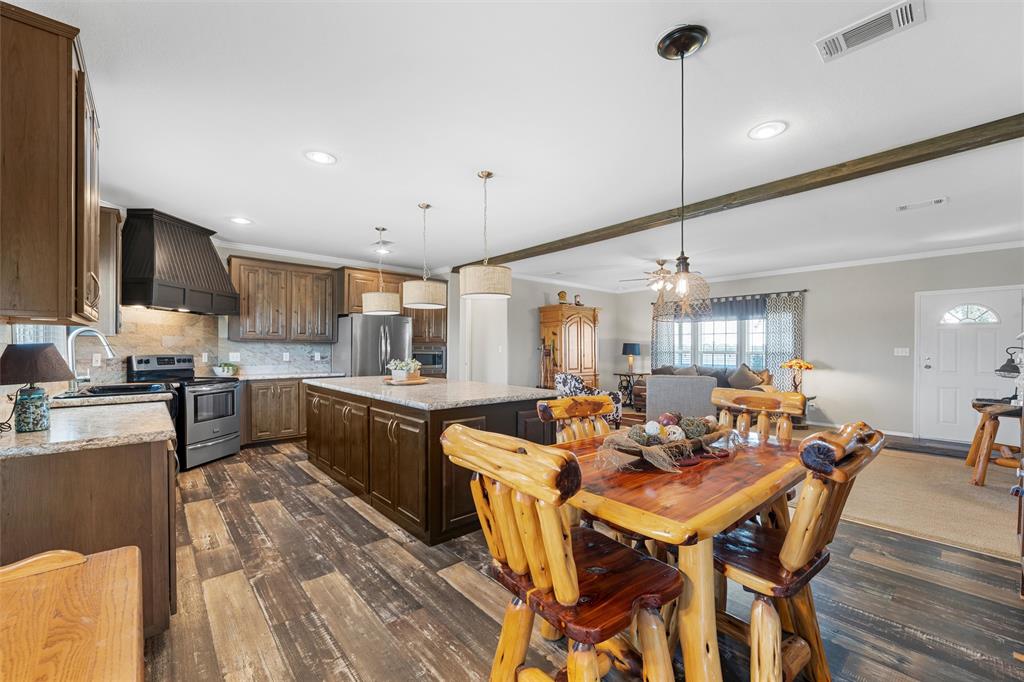 3449 Bluhm Road West, TX 76691 - Photo 9 of 40 Dining area with dark wood-type flooring, crown molding, recessed lighting, a ceiling fan, and beam ceiling