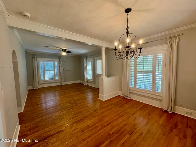 a view of a livingroom with wooden floor and a chandelier