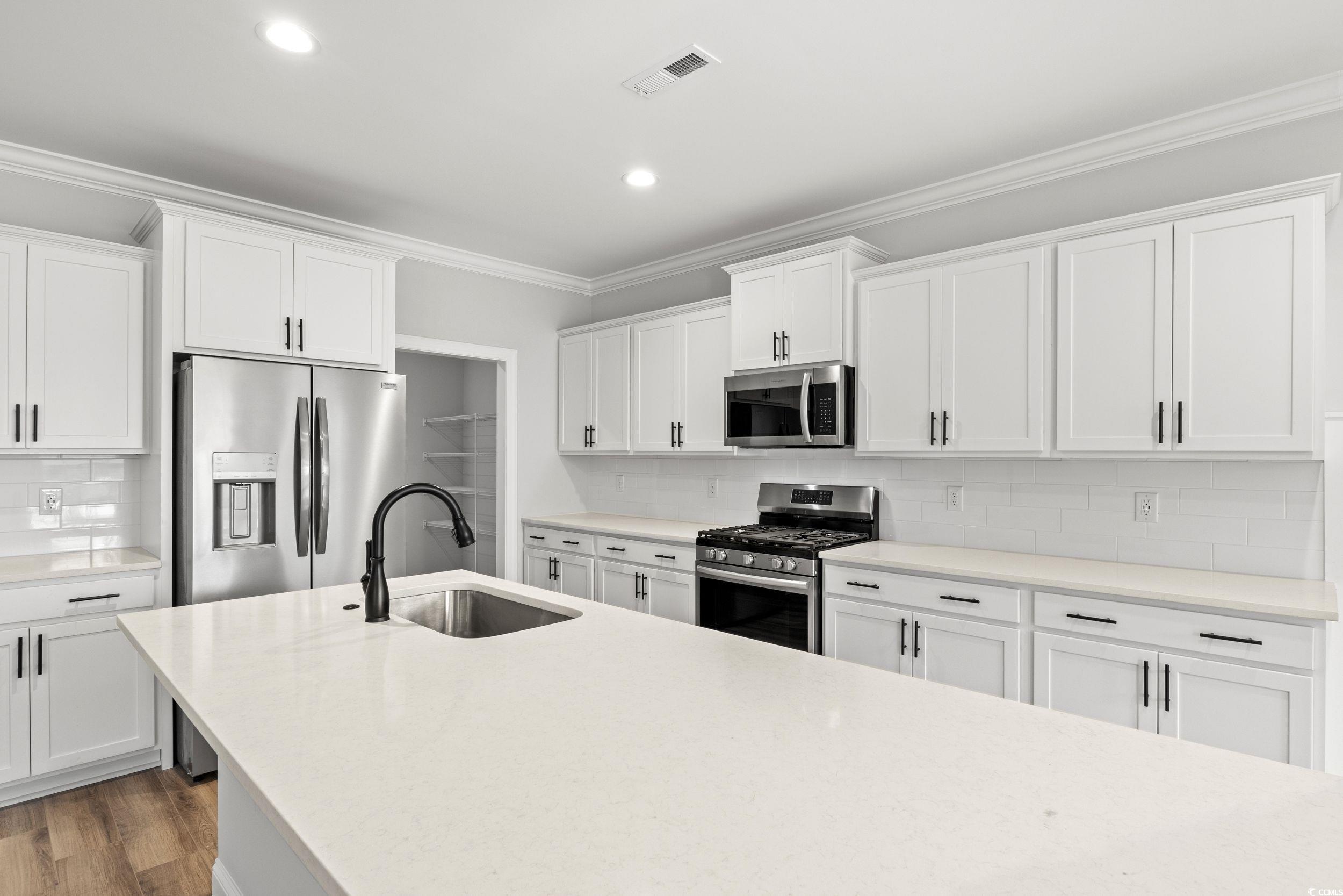 1509 Crooked Hook Road North Myrtle Beach, SC 29582 - Photo 13 of 40 Kitchen featuring white cabinetry, stainless steel