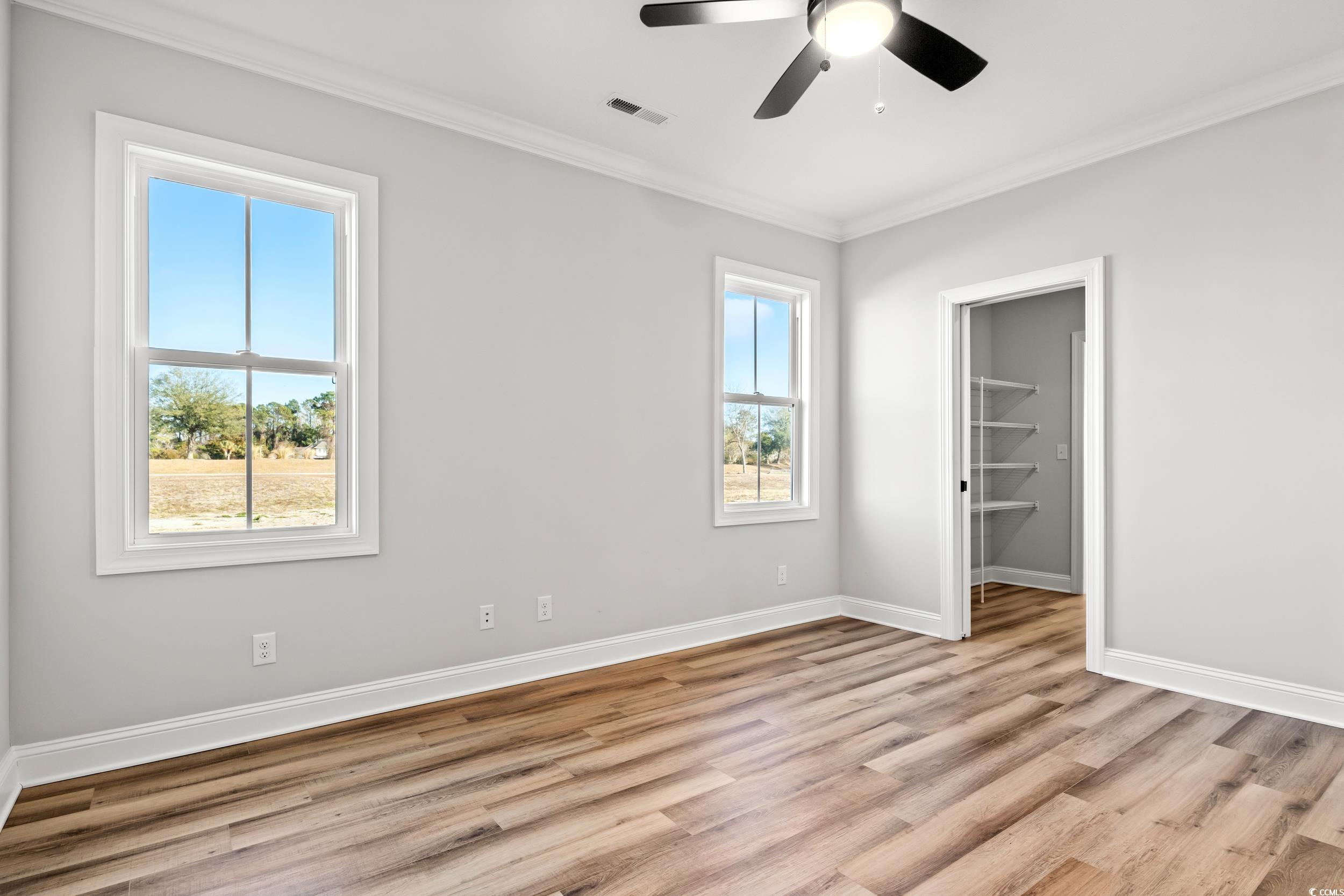 Unfurnished bedroom featuring a walk in closet, or