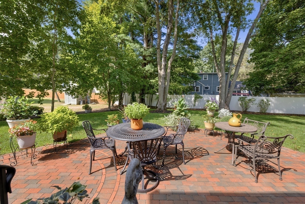 42 Sturges Road Reading, MA 01867 - Photo 33 of 42 a view of a patio with table and chairs potted plants and large tree