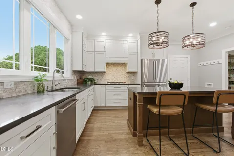 a kitchen with stainless steel appliances granite countertop a stove microwave and cabinets