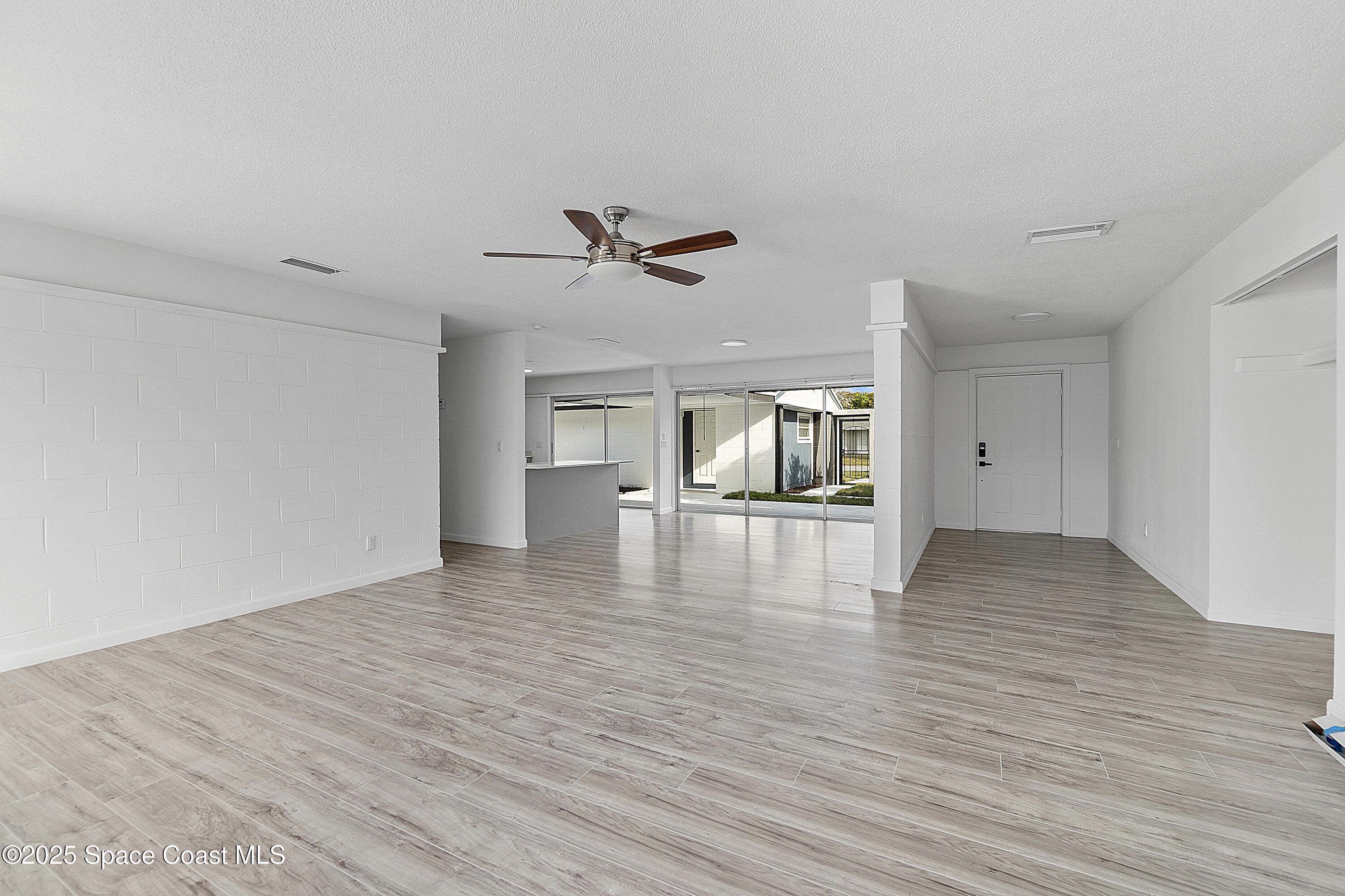 949 Levitt Parkway Rockledge, FL 32955 - Photo 23 of 52 a view of empty room with wooden floor and ceiling fan