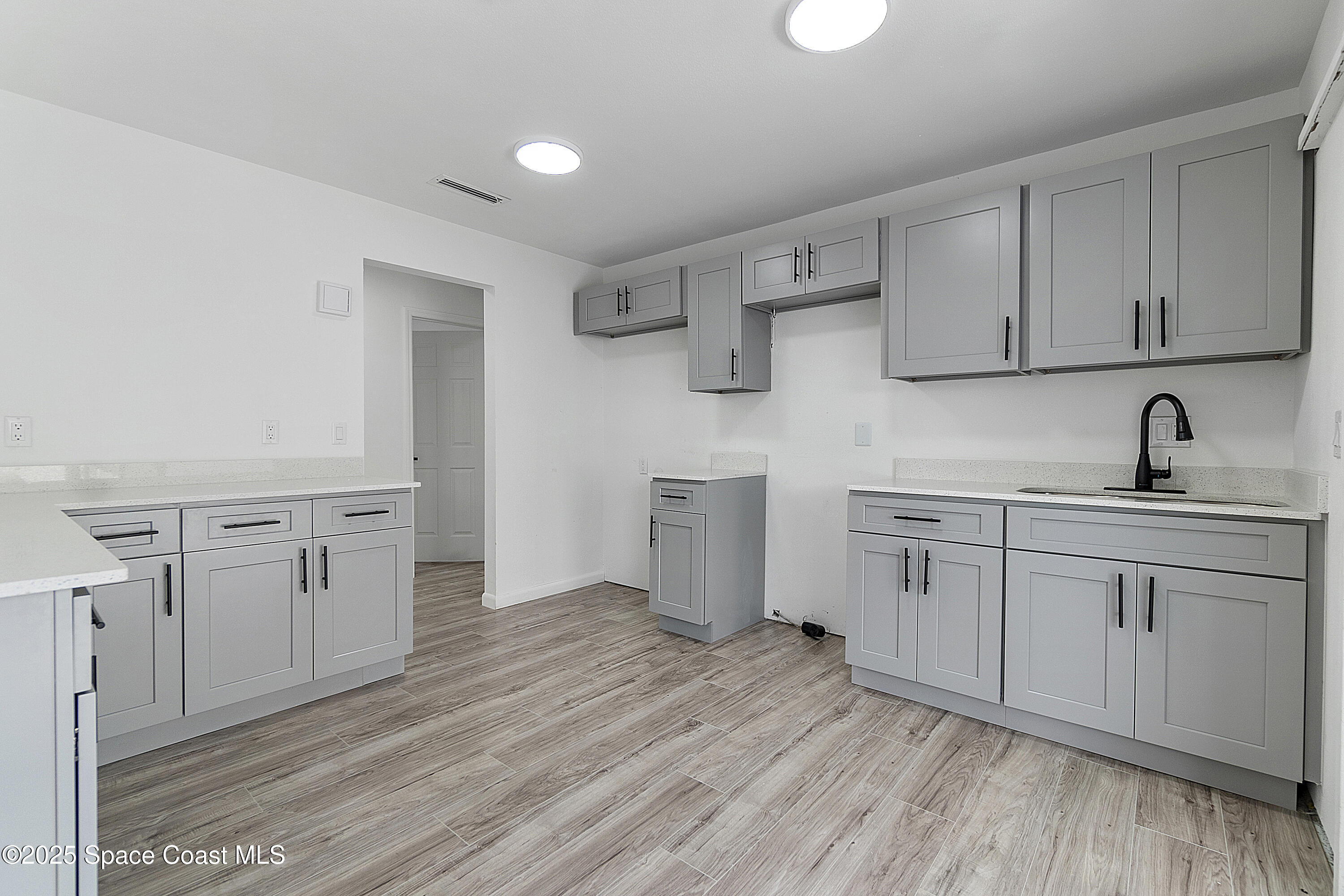 949 Levitt Parkway Rockledge, FL 32955 - Photo 29 of 52 a kitchen with cabinets and wooden floor