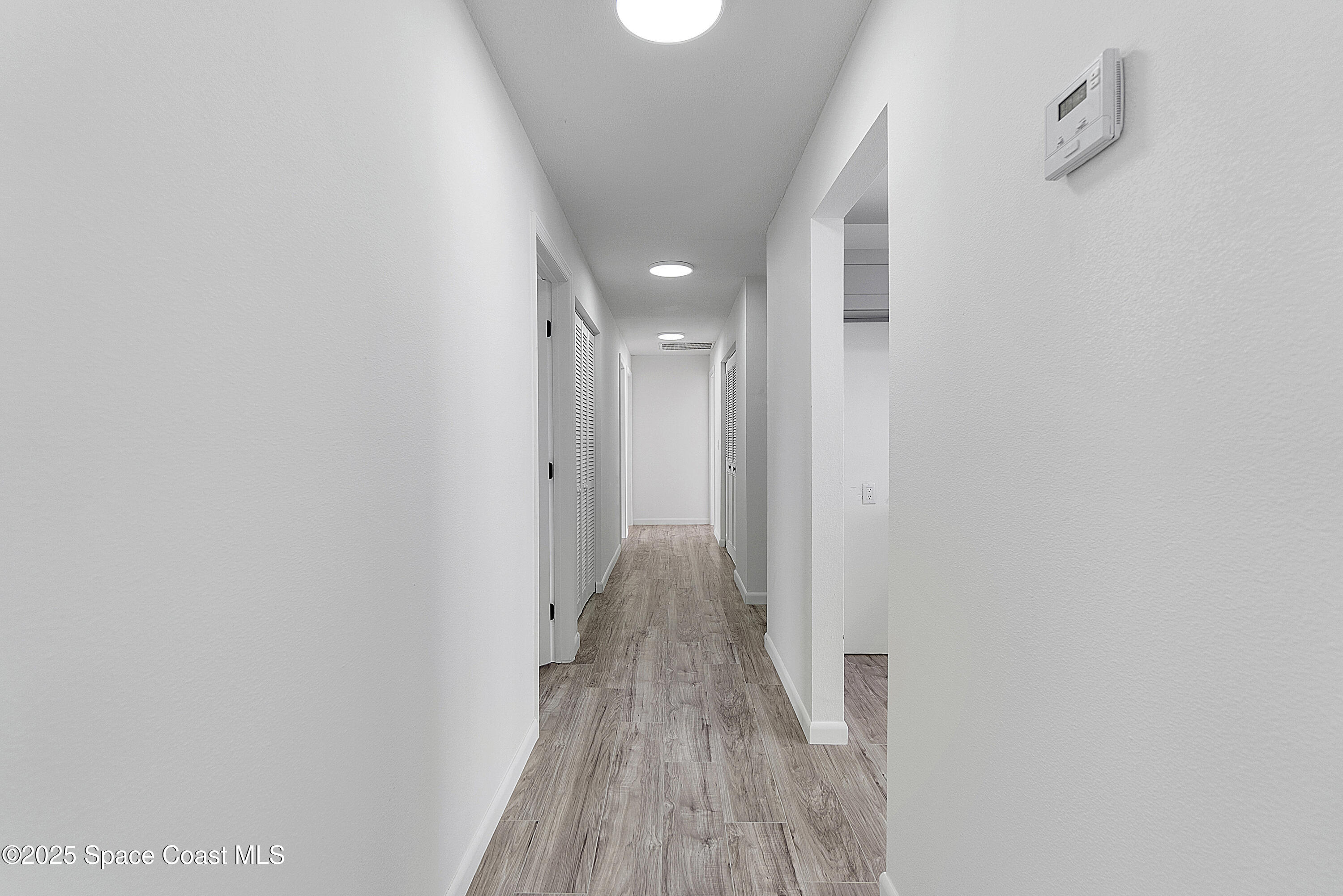 949 Levitt Parkway Rockledge, FL 32955 - Photo 32 of 52 a view of a hallway with wooden floor and a bathroom