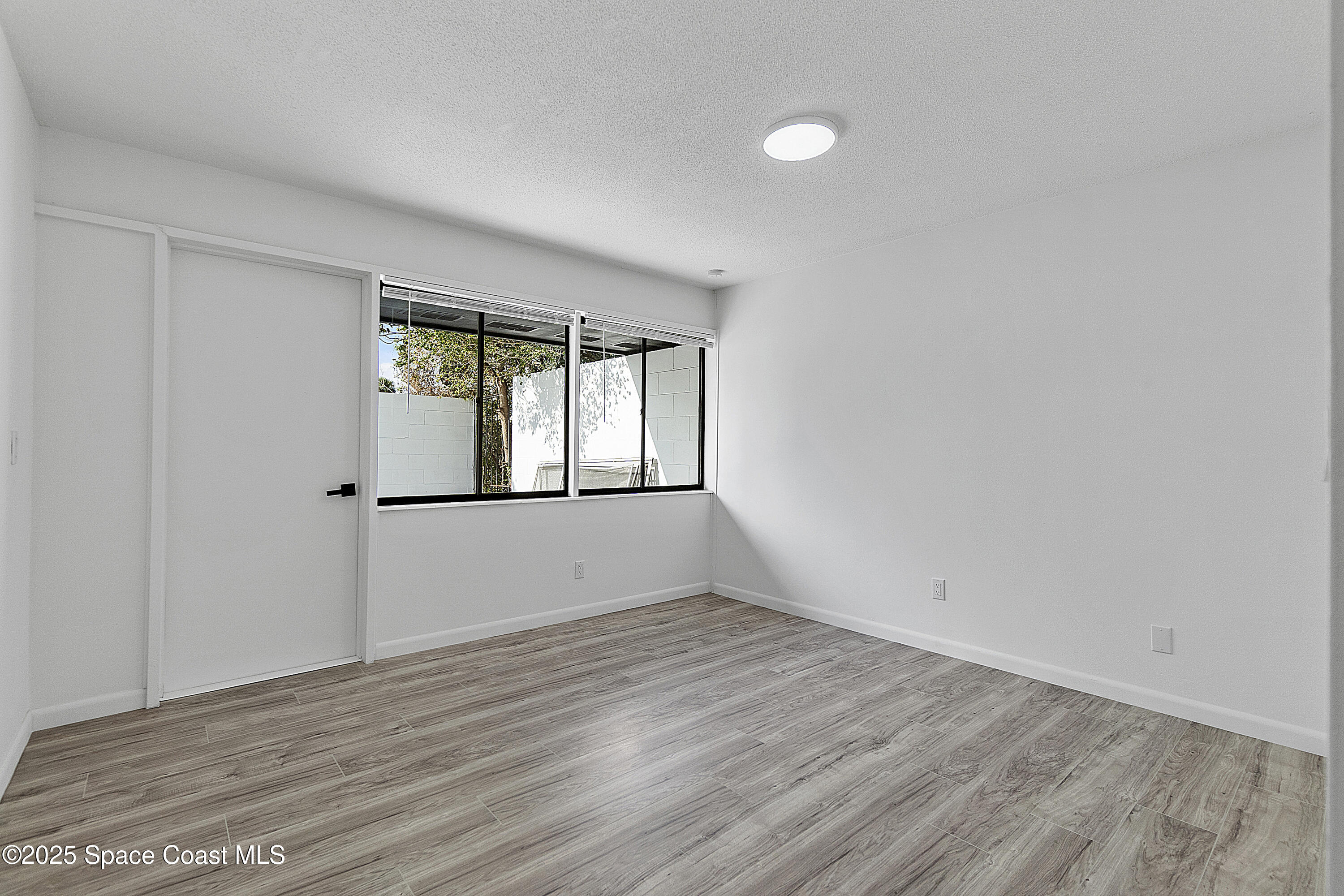 949 Levitt Parkway Rockledge, FL 32955 - Photo 36 of 52 wooden floor in an empty room with a window