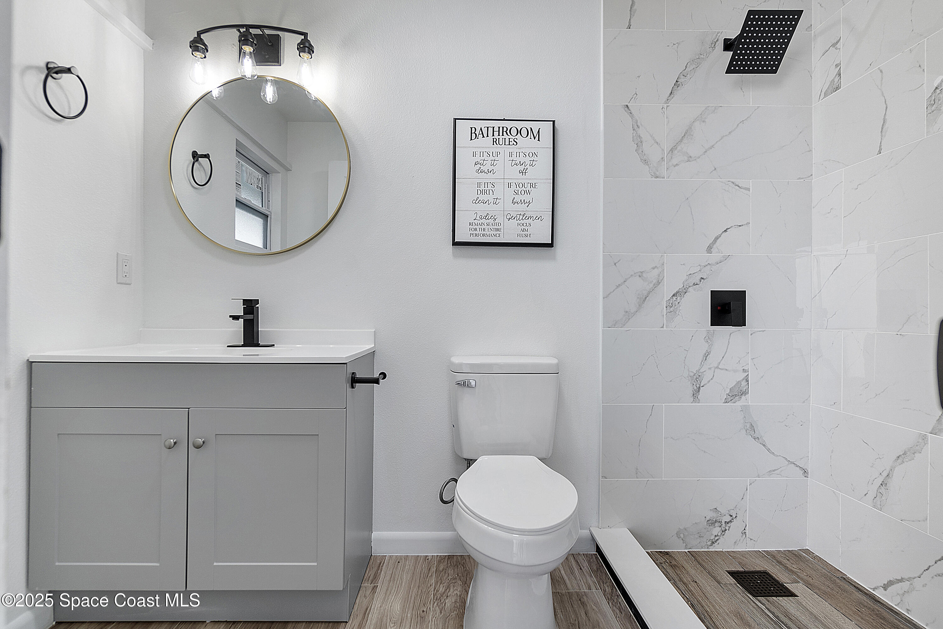 949 Levitt Parkway Rockledge, FL 32955 - Photo 43 of 52 a bathroom with a toilet a sink and a mirror