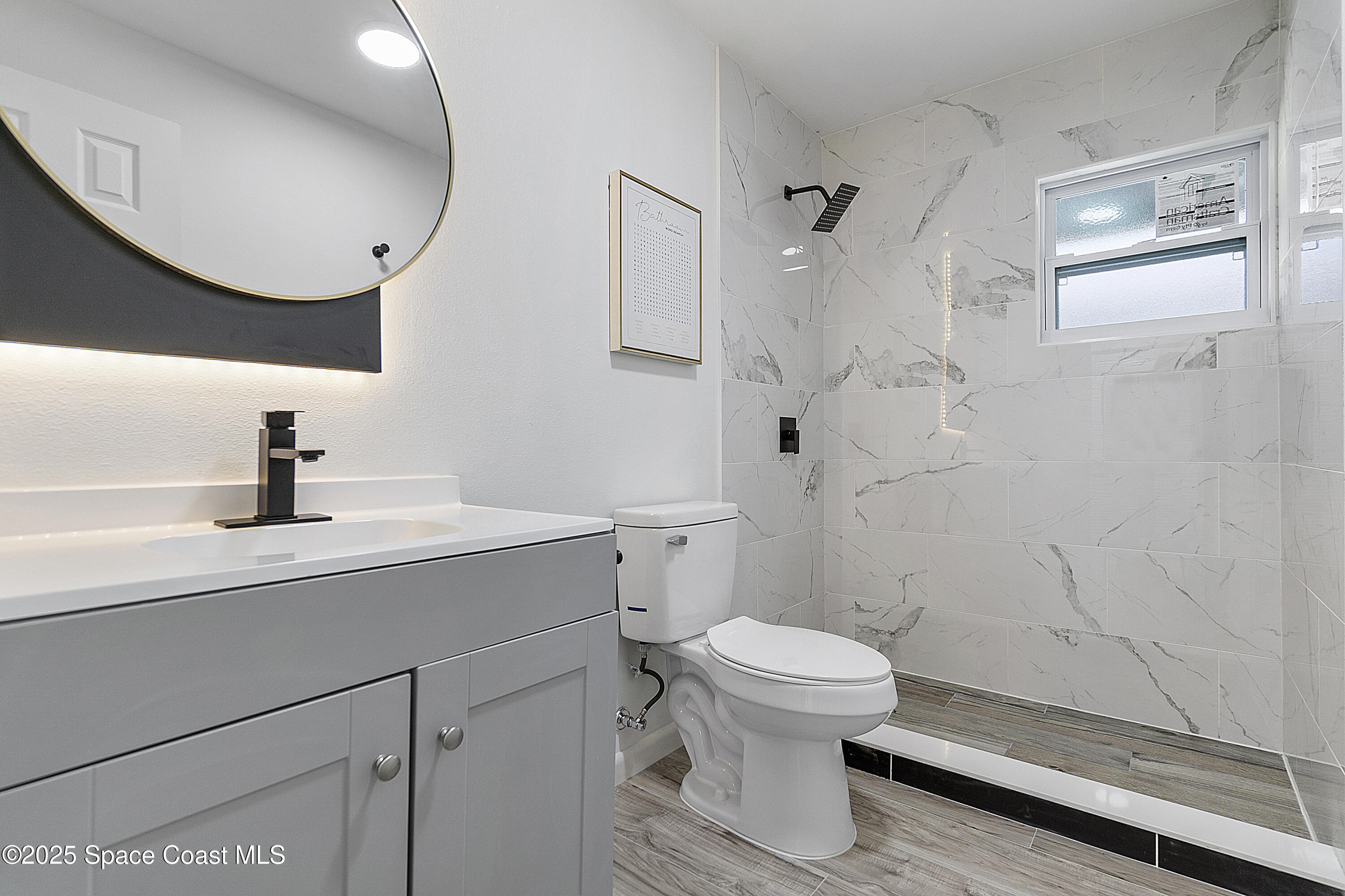 949 Levitt Parkway Rockledge, FL 32955 - Photo 44 of 52 a bathroom with a sink a toilet and a mirror