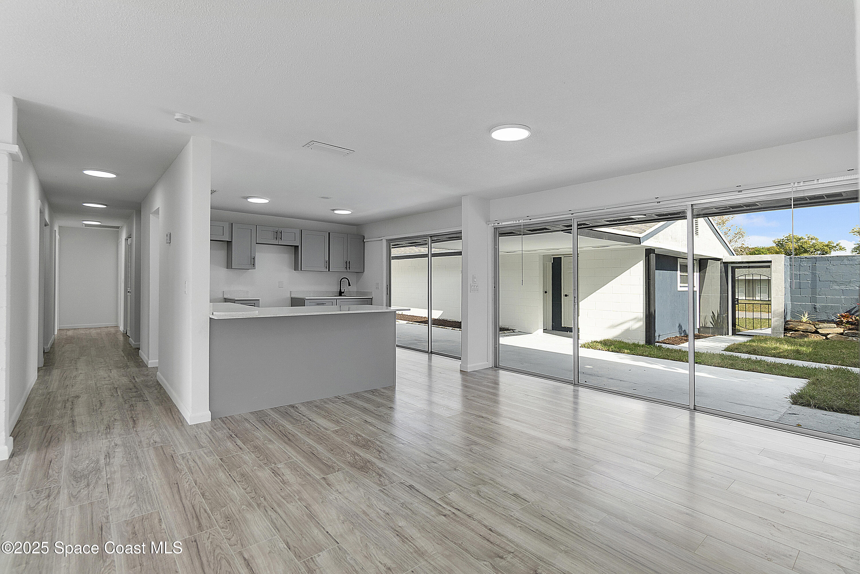 949 Levitt Parkway Rockledge, FL 32955 - Photo 50 of 52 a view of an empty room and kitchen view with wooden floor