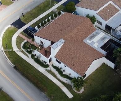 an aerial view of a house with garden space and a car parked on the road