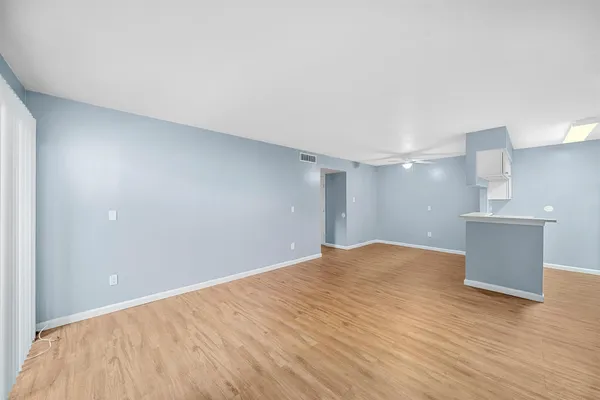 a view of an empty room and wooden floor